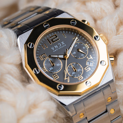 Dames horloge met zilver gouden kast en een zilveren band met gouden schroeven